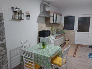 cocina con mesa y sillas y cocina con fregadero en Azalea, en Prilep