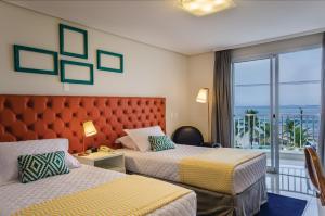Cama ou camas em um quarto em Doral Guarujá