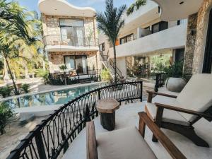 Cet appartement dispose d'un balcon avec une piscine et d'un bâtiment. dans l'établissement Cucu Hotel El Cuyo, à El Cuyo