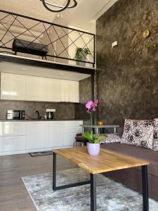 a kitchen and living room with a wooden table at Radio city loft in Kaunas