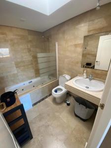 uma casa de banho com um WC, um lavatório e uma banheira em Duquesa village em Manilva