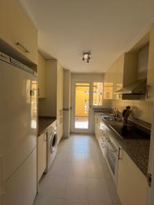 a large kitchen with a washer and dryer in it at Duquesa village in Manilva
