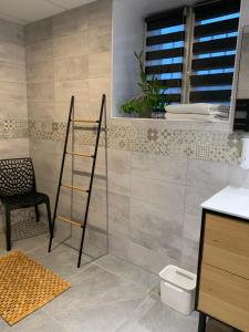 baño con escalera, mesa y silla en La Maison Clémenso, en Cluny