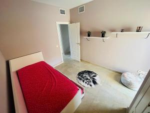 - une chambre avec un lit rouge dans l'établissement Duquesa village, à Manilva