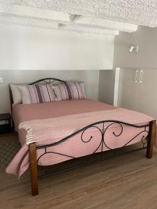 a bedroom with a bed with a pink blanket at Radio city loft in Kaunas