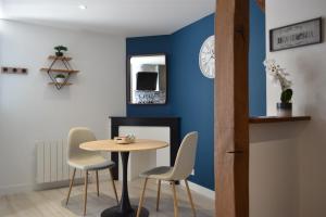 a table and chairs in a room with a blue wall at L'essentiel de Chartres in Chartres