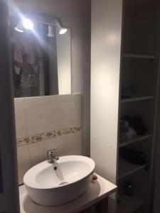 een badkamer met een witte wastafel en een spiegel bij appartement Victor Hugo 2 D et sa pizza offerte in Aurillac