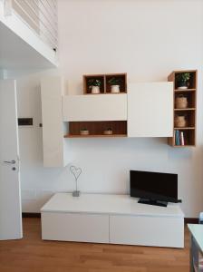 una sala de estar blanca con TV en una pared blanca en Il Nido Bilocale Niguarda, en Milán