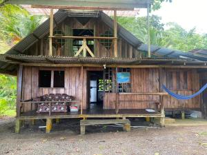 a wooden house with a bench in front of it at Beach house in Drake