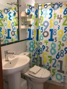 a bathroom with a sink and a toilet and a shower curtain at Apartamentos Concha in Valle Gran Rey