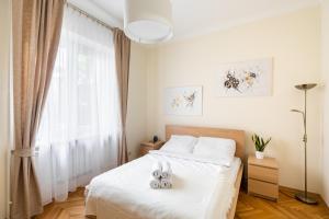 una camera da letto con un letto con lenzuola bianche e una finestra di P&O Serviced Apartments Plac Konstytucji a Varsavia