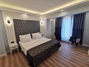 a bedroom with a large bed with a large headboard at Luxx Garden Hotel in Istanbul