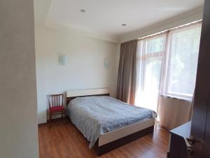 a bedroom with a bed and a window at Bakuriani K-2 Apartment in Bakuriani