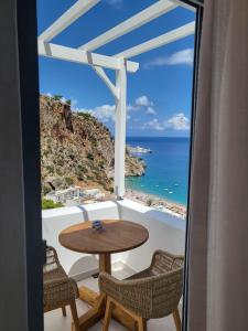 una mesa y sillas en un balcón con vistas al océano en Agnantema luxury suites, en Karpathos