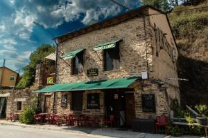 a brick building with tables and chairs in front of it at El Puente Peregrino in Trabadelo