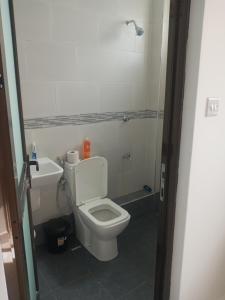 y baño con aseo blanco y lavamanos. en Amber Apartment, en Mombasa