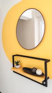 a mirror on a yellow wall with a wooden shelf at Amanecer del Fuego II in Ushuaia