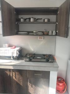 um fogão numa cozinha com panelas e frigideiras em Amber Apartment em Mombaça