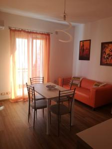 a living room with a table and chairs and a couch at Alice apartment in Salemi