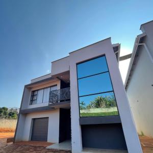 a modern house with a large glass door at Ezulwini Executive Apartments in Lobamba