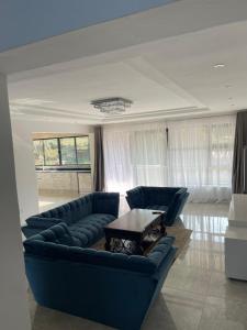 a living room with a blue couch and a table at Ezulwini Executive Apartments in Lobamba