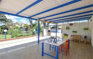 een patio met een tafel en stoelen onder een pergola bij Amazing Home In Chiaramonte Gulfi With Private Swimming Pool, Can Be Inside Or Outside in Chiaramonte Gulfi
