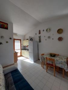 a kitchen with a table and a refrigerator at Villetta a 350 m dal mare in Costa Rei