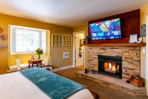 a bedroom with a fireplace with a television above it at J Patrick Inn in Cambria