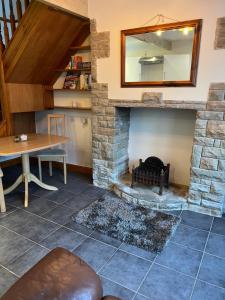 a living room with a stone fireplace and a table at Cosy cottage with a canal view in Hebden Bridge