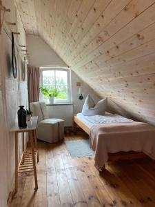 1 dormitorio con cama y techo de madera en Pasterhof Eichhorst en Friedland