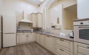 a kitchen with white cabinets and a white refrigerator at Family apart in Odesa