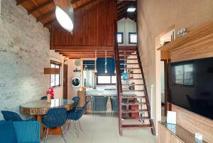 巴拉大的住宿－Ap. Peixe Boi Pé na areia com vista frontal e total para o mar，厨房以及带桌子和蓝色椅子的用餐室。