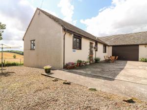 a detached house with a garage and a driveway at Courtyard Cottage in Duns