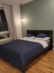 um quarto com uma cama grande e almofadas azuis em M2 Bemowo apartament em Warszawa