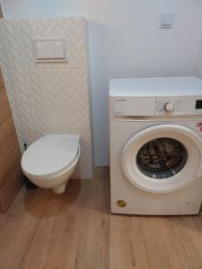 uma casa de banho com uma máquina de lavar roupa e um WC em M2 Bemowo apartament em Warszawa