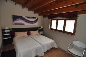 a bedroom with a white bed and a window at Restaurant & Rooms Cabrit in Sant Mateu