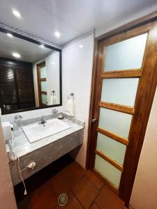 y baño con lavabo y espejo. en Parador del Dominico en Oaxaca de Juárez