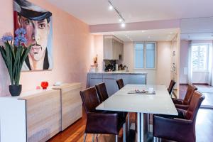 蒙特勒Montreux Grand Rue - Swiss Hotel Apartments的配有桌椅的厨房和餐厅