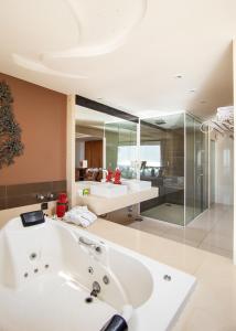 y baño con bañera blanca grande. en Costa do Sol Boutique Hotel, en Búzios