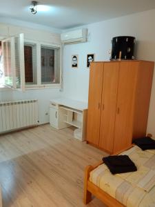 a bedroom with a desk and a bed and a cabinet at Marakana Apartment-free parking space 2 in Dedinje