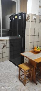 una nevera negra en una cocina con mesa en Apartments Haagna en Ashdod