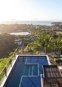 a swimming pool with a view of the ocean at Costa do Sol Boutique Hotel in Búzios