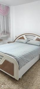 1 cama blanca en un dormitorio con ventana en Apartments Haagna en Ashdod