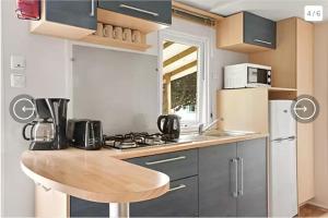 a small kitchen with a counter and a sink at Mobil-Home Camping de la dune Blanche in Camiers