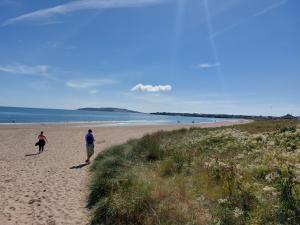 um homem e uma mulher a caminhar numa praia em Seaside Apartment with Seaview in Dublin 3 close to city centre em Dublin