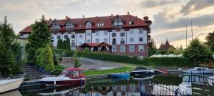 duży budynek z łodziami zacumowanych w zbiorniku wodnym w obiekcie Apartamenty Przy Porcie 54m2 oraz 31m2 z Tarasem w Węgorzewie