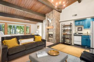 a living room with a couch and a kitchen at Aspenwood by Snowmass Vacations in Snowmass Village