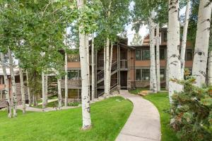 a building with trees in front of a sidewalk at Aspenwood by Snowmass Vacations in Snowmass Village