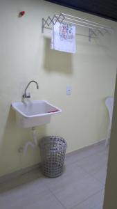 - Baño con lavabo blanco y cesta en Casa completa, simples e aconchegante em Urubici., en Urubici