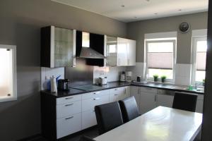 a kitchen with white cabinets and a table with chairs at Ferienwohnung Grove in Bippen